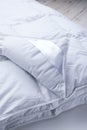 A corner of a white duvet blanket close-up. Close up Blanket against a white background. Royalty Free Stock Photo