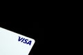 White VISA credit card on plain black background