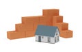 Cornered stack of red brick stones and miniature house model on white background, construction, building trade or masonry industry