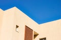 Corners and lines geometric shapes of concrete small building apartment foreshortening from below with blue sky background