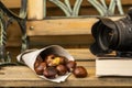 A cornet of roasted chestnuts in front of a camera lens Royalty Free Stock Photo