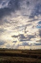 Cornfield with wind generators and a sky with clouds and sunbeams. Renewable energy concept Royalty Free Stock Photo