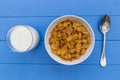 Cornflakes breakfast cereal bowl with milk on wood table background