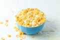 Cornflakes dry breakfast with milk. The blue plate is full of cereal and milk. Isolated on white background. Royalty Free Stock Photo