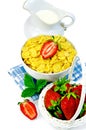 Cornflakes with milk in a jug and strawberries