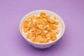 Cornflakes with milk at pink background