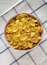 Cornflakes in a pink bowl for breakfast, top view. Flat lay, overhead, from above