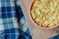 Cornflakes in a pink bowl, on a wooden table. copy space