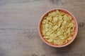 Cornflakes in a pink bowl, on a wooden table. copy space