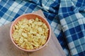 Cornflakes in a pink bowl, on a wooden table. copy space