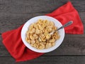 Cornflakes in plate with red napkin on wood