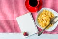 Cornflakes, strawberry, milk and a cup of coffee for breakfast