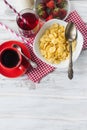 Cornflakes, strawberry, milk and a cup of coffee for breakfast