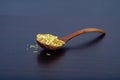 Cornflakes in wood spoon on a dark wooden