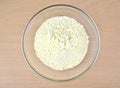 Cornflour in a glass bowl on wooden background.