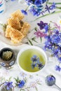 Cornflower herbal tea in white cup on white crochet napkin intdoors, healthy cornflower drink with honey