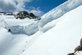 Cornices of snow on top of a snowy and sunny mountain