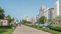 Corniche boulevard beach park along the coastline in Abu Dhabi with skyscrapers on background.