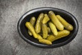 Cornichons in Black Dish on Slate Top View Royalty Free Stock Photo