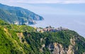 Corniglia traditional typical Italian village with colorful buildings on rock cliff and Manarola, Genoa Gulf, Ligurian Sea, blue s