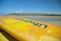 Cornish beach with yellow Lifeguards surfboard diagonally in the frame