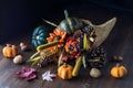 Cornucopia centrepiece filled with autumn decorations against a black background. Royalty Free Stock Photo