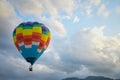 Coroful Hot Air Ballon Flying In The sky with clouds and mountain background Royalty Free Stock Photo