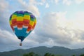 Coroful Hot Air Ballon Flying In The sky with clouds and mountain background Royalty Free Stock Photo