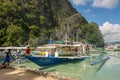 Tourist boats with tourists by the beach of a small island in the sea. Coron, Philippines