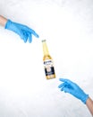 Corona beer with two blue protective gloves