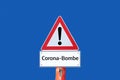 Corona bomb warning sign on blue background in german Royalty Free Stock Photo