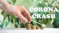 Corona crash. Woman stacking coins on wooden table