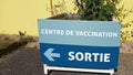 Corona vaccination center exit arrow after vaccine text sign french for Covid-19 vaccination superstation