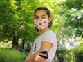 Corona virus  and diabetes. Girl with the mask on face is reading glucose level from the white sensor on left arm. Royalty Free Stock Photo