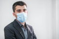 Business man portrait wearing protective mask in a white background