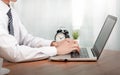 Coronavirus.Business man working on laptop computer  at home while sitting the wooden table.Male hands typing on the notebook Royalty Free Stock Photo