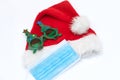 Coronavirus Christmas Santa hat and medical mask with festive new year glasses on white background. The concept of self Royalty Free Stock Photo