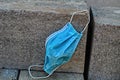 Coronavirus, concept. A blue surgical mask thrown or forgotten by the owner at a construction site, on expanded clay blocks Royalty Free Stock Photo