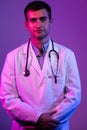 Coronavirus covid-19 danger alert Portrait of hero in white coat. Cheerful smiling young doctor with stethoscope in