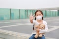 Coronavirus covid-19 and pollution protection concept. Asian little child girl hugging teddy bear doll with wearing mask and show Royalty Free Stock Photo