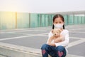 Coronavirus covid-19 and pollution protection concept. Asian little child girl hugging teddy bear doll with wearing mask to Royalty Free Stock Photo