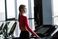 Coronavirus covid-19 prevention, fitness girl with a medical mask posing in gym. Fighting viruses Royalty Free Stock Photo