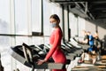 Coronavirus covid-19 prevention, fitness girl with a medical mask posing in gym. Fighting viruses Royalty Free Stock Photo