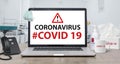 Coronavirus or Covid-19 text on laptop background concept. Mockup deskphone with facial masks and Alcohol Hand Sanitizer on worki