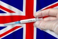 Coronavirus COVID-19 vaccination concept in United Kingdom of Great Britain and Northern Ireland with doctor hand and syringe Royalty Free Stock Photo