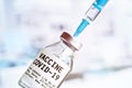 Coronavirus covid-19 vaccine concept - glass bottle with silver cap hypodermic syringe needle injected, closeup detail sticker