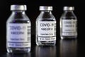 Coronavirus Covid-19 vaccine concept - three glass vials on black table, closeup detail own design - dummy bar code