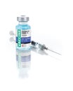 Coronavirus COVID-19 Vaccine Vial and Syringe On Reflective White Background