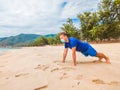 Coronavirus COVID 19. Young beautiful man doing sport performing workouts exercises and push up near sea in the morning