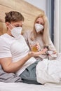coronavirus CoVid-19 young couple at home with seasonal winter cold illness disease lie on bed
